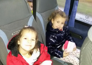 Widok na dwie dziewczynki siedzące w autokarze.